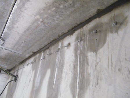 The packers were inserted into the concrete retaining wall in the basement, and resin injected into the concrete.  Seepage is already noticeably reduced, at Kells, Ballymena, Co. Antrim, Northern Ireland