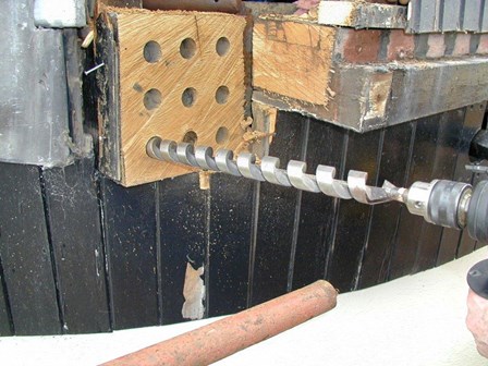 Reclaimed wood was drilled in order to resin splice it onto the existing timber sails, at Millisle, Co. Down, Northern Ireland