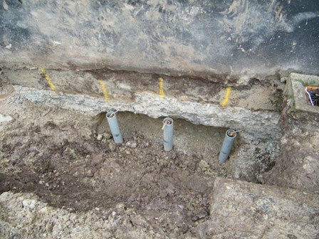 External trench dug and helical shire piles to underpin the dwelling at Ballykelly, Co. Londonderry, Northern Ireland